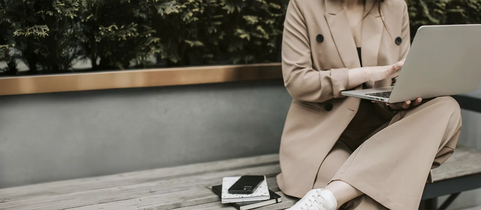 Woman on a bench outside working on her laptop, represents how Susan Podbielski therapy and coaching services are designed to fit your busy life.