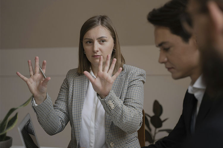 Woman in a business meeting, represents how high-achieving women struggle to set work boundaries.