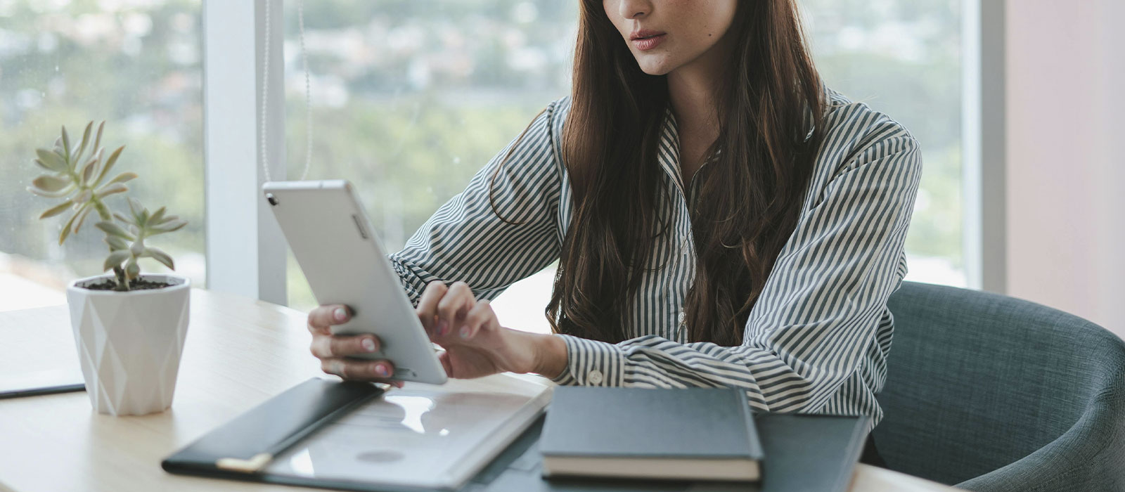Professional woman reading on her tablet, represents how you can find free downloads and resources by Susan Podbielski.