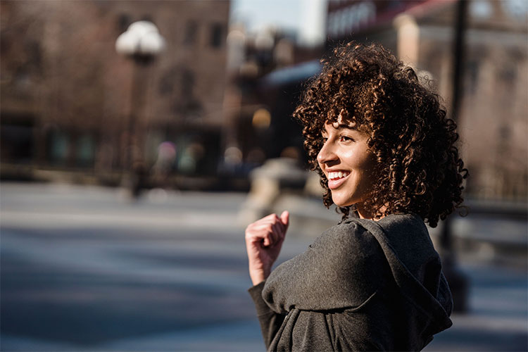 Joyful woman exercises outdoors in a city, represents changes in your life when you go from insight to action.
