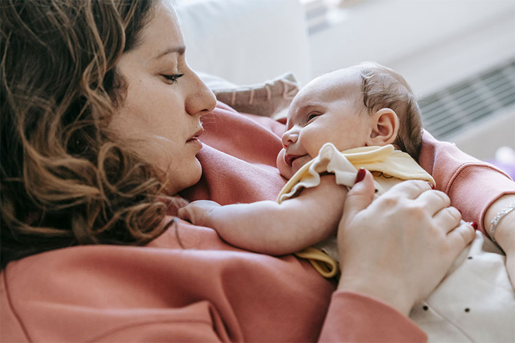 New mother holding her baby, represents why getting help for postpartum depression matters.